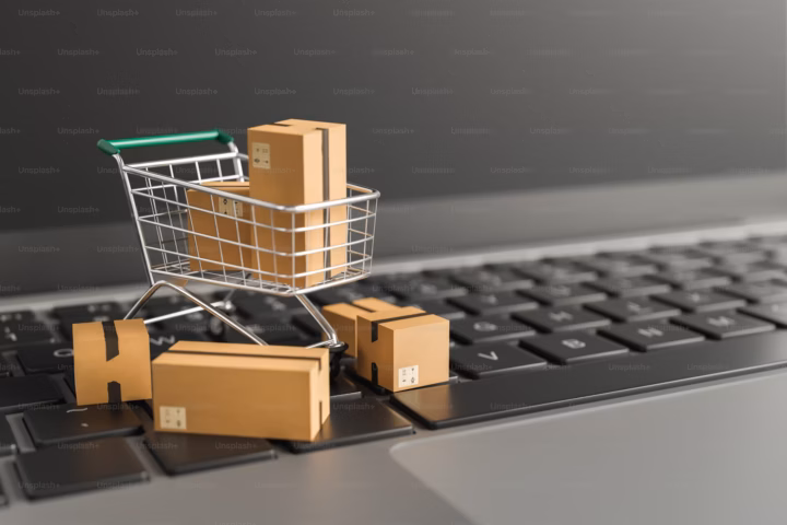 Einkaufswagen mit Boxen innen drin auf einer Tastatur.